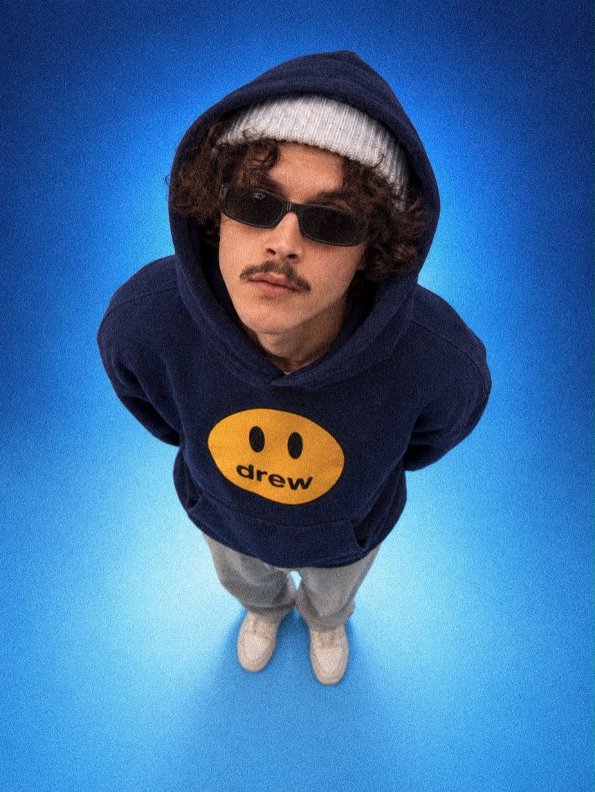 Deeko de moletom azul, gorro e óculos escuros, visto de cima